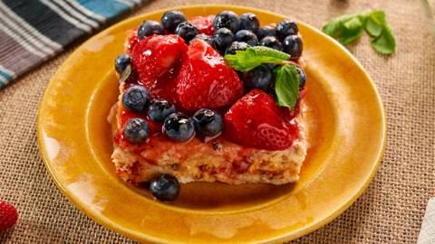 Бисквитена торта с маскарпоне и сладко от ягоди, поднесена с пресни ягоди и боровинки